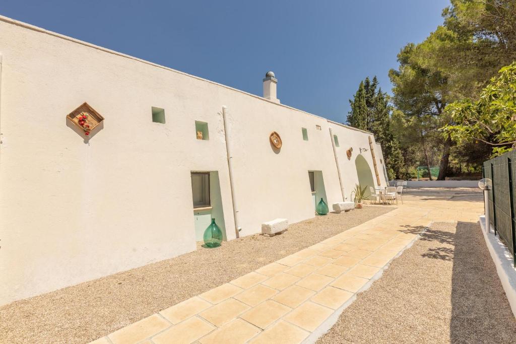 un bâtiment blanc avec un trottoir à côté dans l'établissement Villa Le Terracate, à Lido Marini