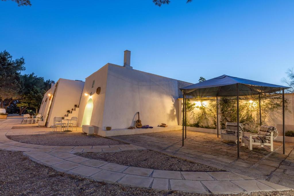 - une terrasse avec un parasol à côté d'un bâtiment dans l'établissement Villa Le Terracate, à Lido Marini