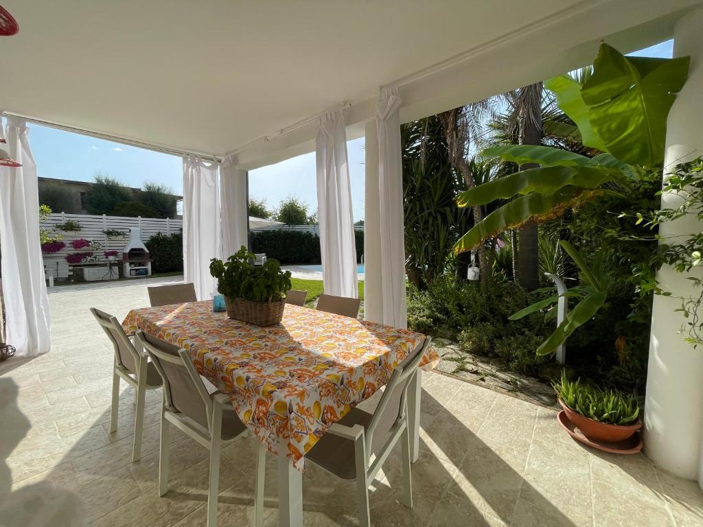 une salle à manger avec une table et des chaises dans l'établissement Edri beach house - Villa con piscina, à Pontecagnano