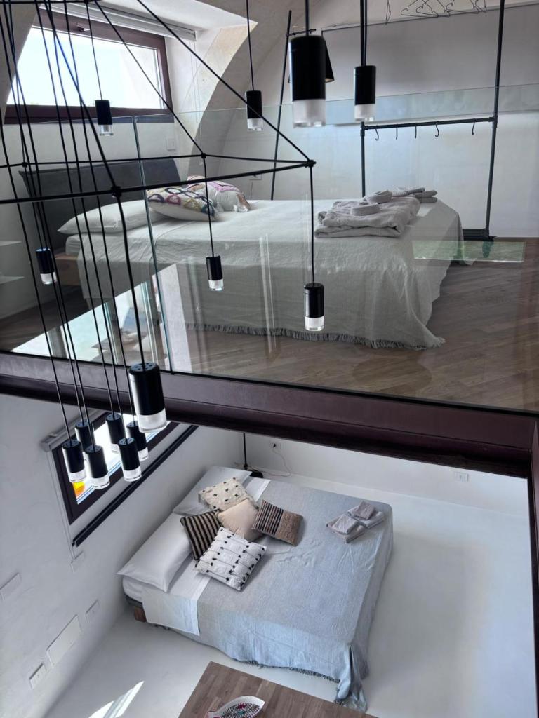 Cette chambre comprend 2 lits et un miroir. dans l'établissement Aeneas Villa Pool & Jacuzzi al mare Torre Guaceto, à Specchiolla 46 autres photos