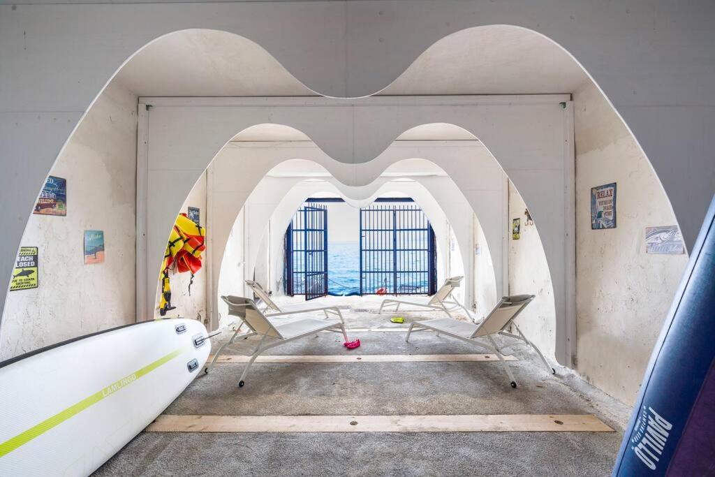une chambre avec une planche de surf dans une pièce avec une arche dans l'établissement Design house with pool & direct access to the sea, à Santa Flavia
