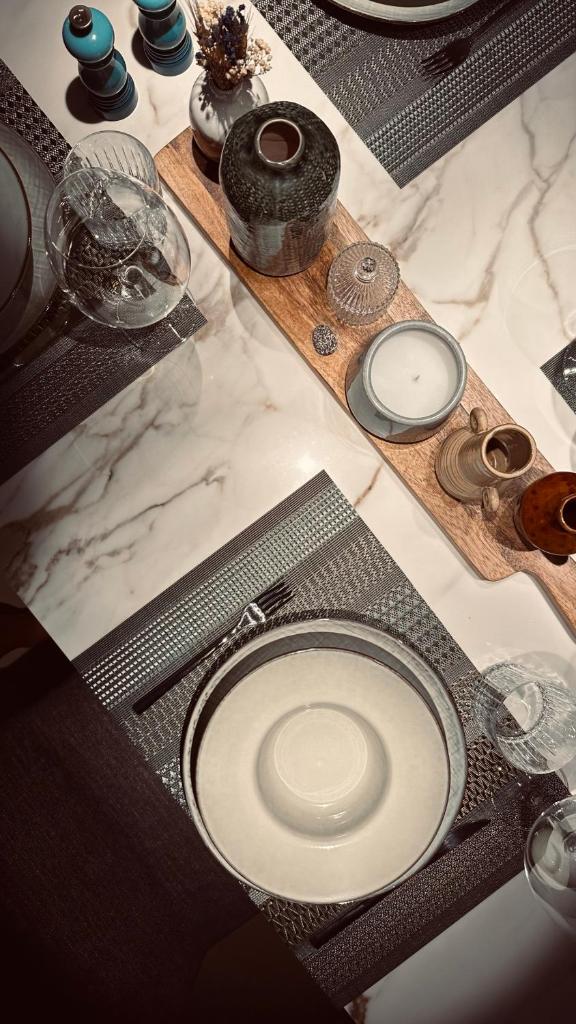 une table avec plaques et autres éléments y figurant dans l'établissement Isaia Luxury, à San Martino della Battaglia