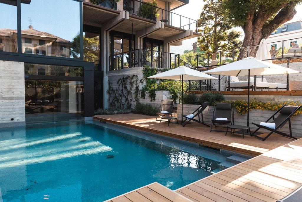 une piscine avec chaises et parasols à côté d'un bâtiment dans l'établissement Capitolo Riviera, à Gênes