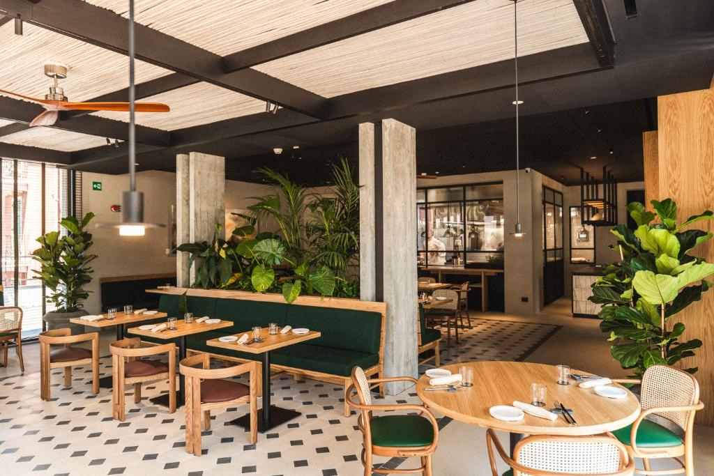 un restaurant avec des tables et des chaises en bois et des plantes dans l'établissement Capitolo Riviera, à Gênes