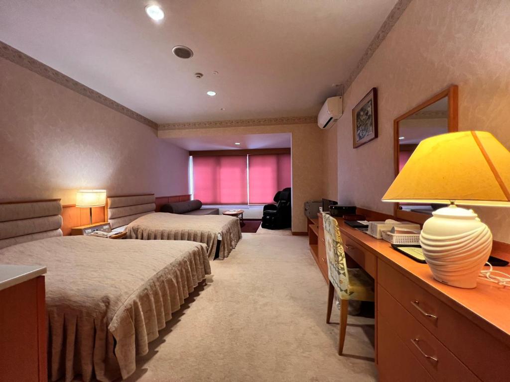 Cette chambre comprend deux lits et un bureau avec une lampe. dans l'établissement Hotel Miki, à Gero 33 autres photos