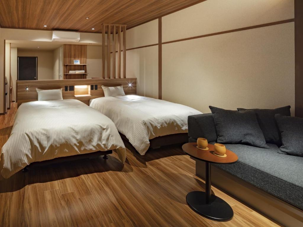 une chambre d'hôtel avec deux lits et un canapé dans l'établissement Azumakan, à Nihommatsu