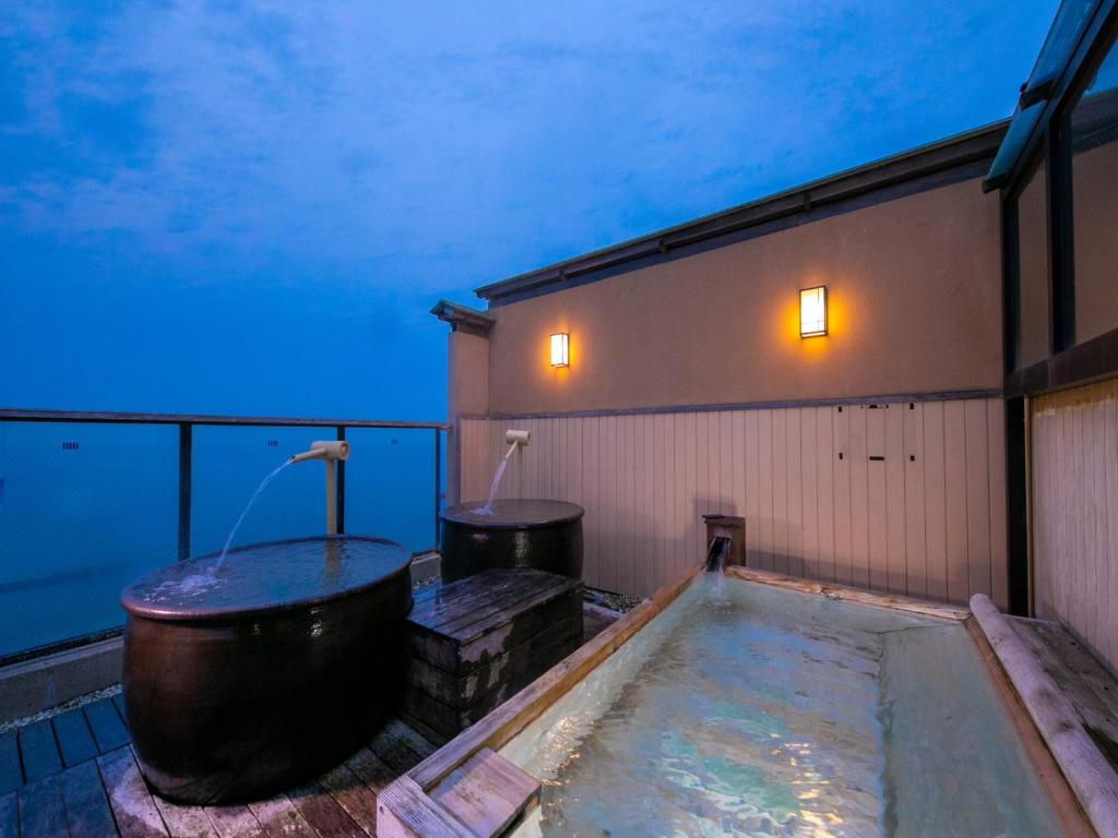 une baignoire posée sur le côté d'un bâtiment dans l'établissement Genjiko, à Minamichita