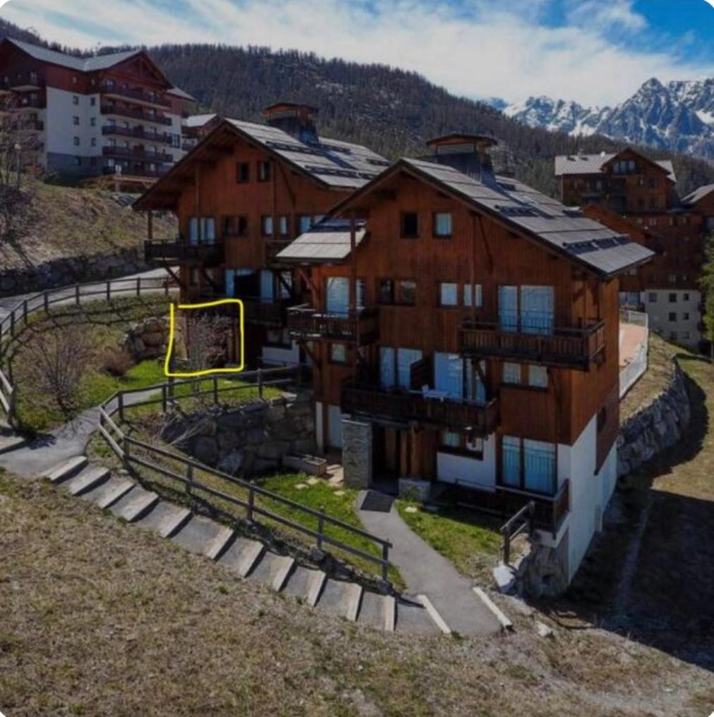 une vue aérienne sur un bâtiment avec des montagnes en arrière-plan dans l'établissement Appartement 6 personnes à Puy-Saint-Vincent, à Puy-Saint-Vincent
