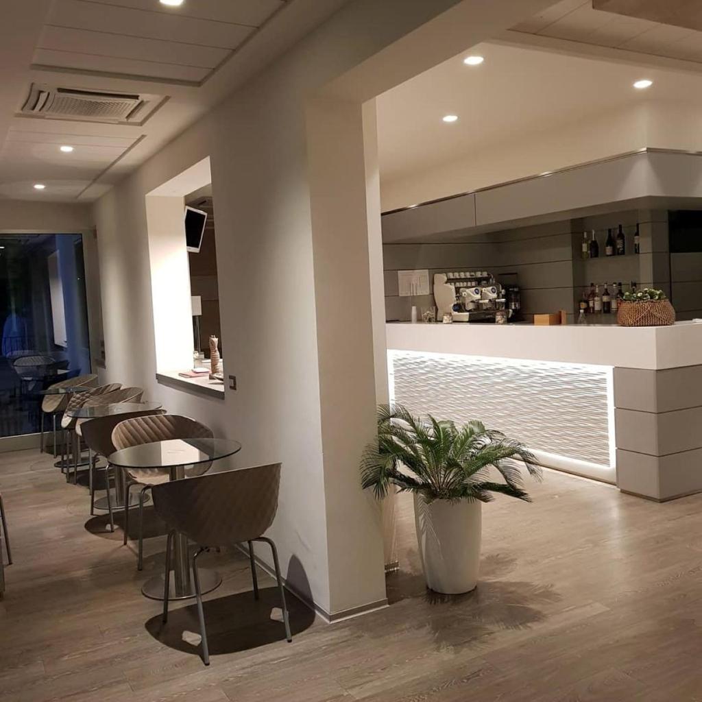 un restaurant avec une rangée de tables et de chaises dans l'établissement Albergo Aquila, à Rimini