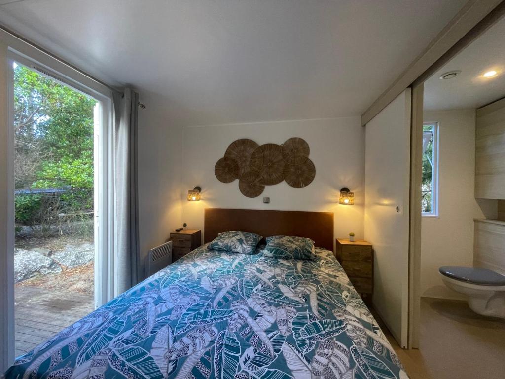 une chambre avec un lit et une fenêtre dans l'établissement MOBILE HOME 3 CHAMBRES TERRASSE 50 M2, à Seignosse