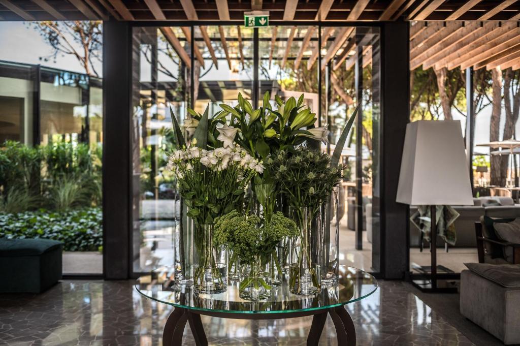 un vase de fleurs sur une table dans le hall dans l'établissement Bellevue Hotel & Resort, à Lido di Jesolo