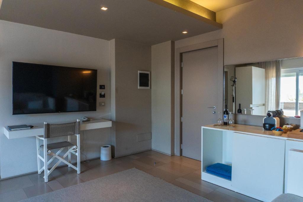 une cuisine avec une télévision et un comptoir avec une chaise dans l'établissement Il Fogliano Hotel New Life, à Latina