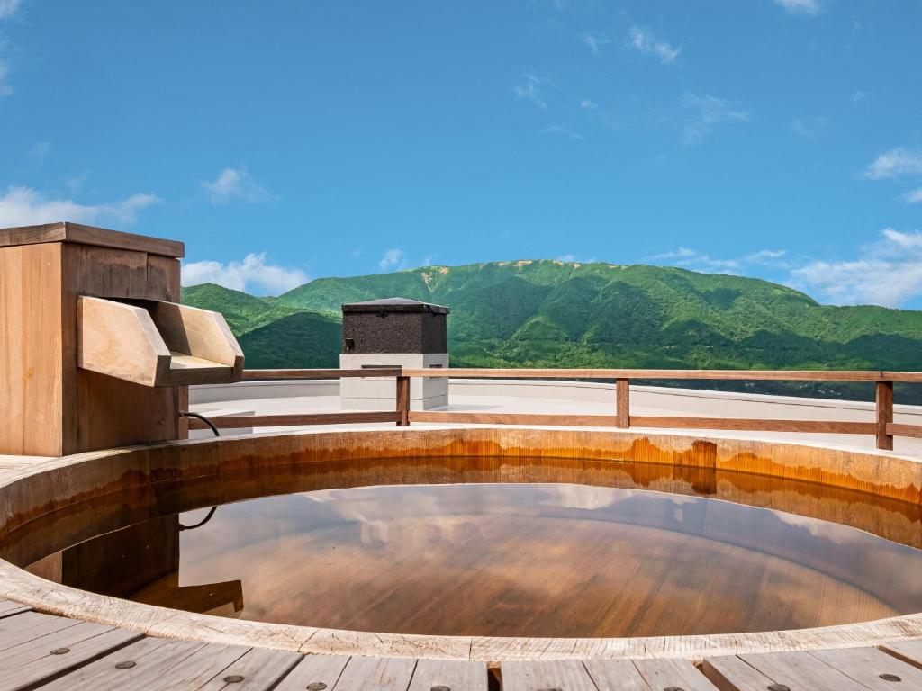 une piscine sur une terrasse avec des montagnes en arrière-plan dans l'établissement Nagominoyado Hanagokoro - Reopening in Mar 2024, à Hakone