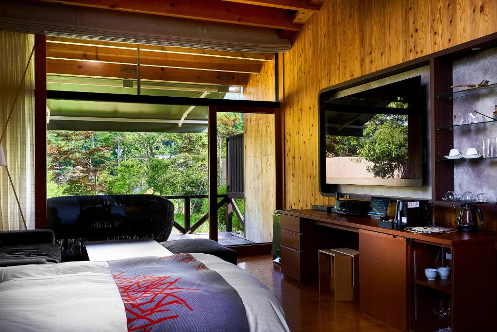 une chambre avec un lit et une télévision à écran plat dans l'établissement Sanso Amanosato, à Katsuragi