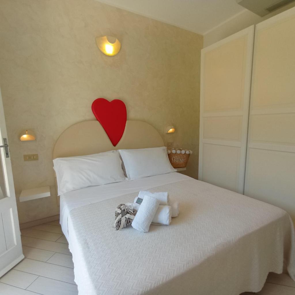 une chambre avec un lit avec un cœur sur le mur dans l'établissement Hotel Raul, à Riccione 53 autres photos