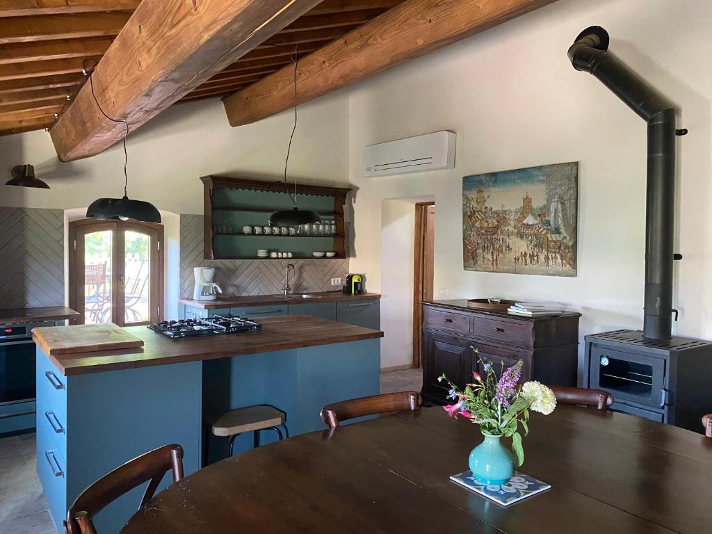 une cuisine avec une table avec un vase de fleurs dessus dans l'établissement Le Gualchiere, à Volterra