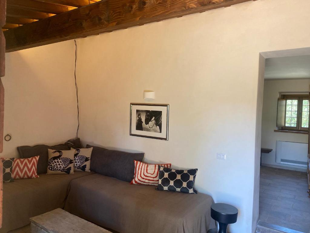 - un salon avec un canapé et des oreillers dans l'établissement Le Gualchiere, à Volterra