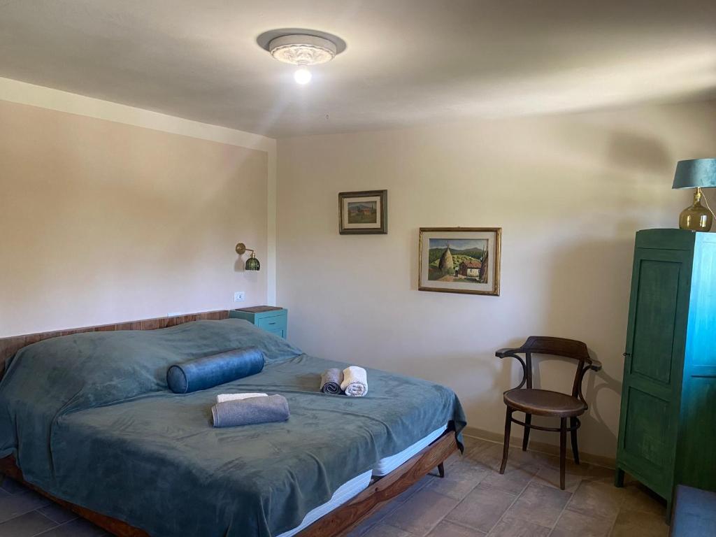 une chambre avec un lit et une chaise dans l'établissement Le Gualchiere, à Volterra 31 autres photos