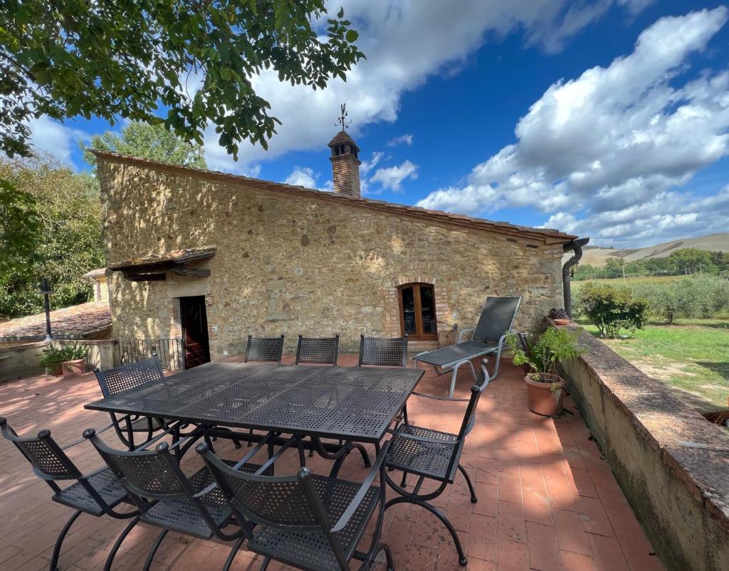 un patio avec une table et des chaises devant un bâtiment dans l'établissement Le Gualchiere, à Volterra