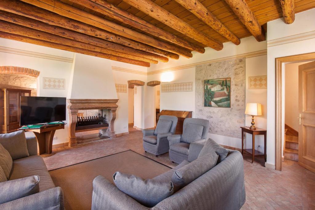 un salon avec un canapé, des chaises et une télévision dans l'établissement Cà Cantoni With Pool, à Garde