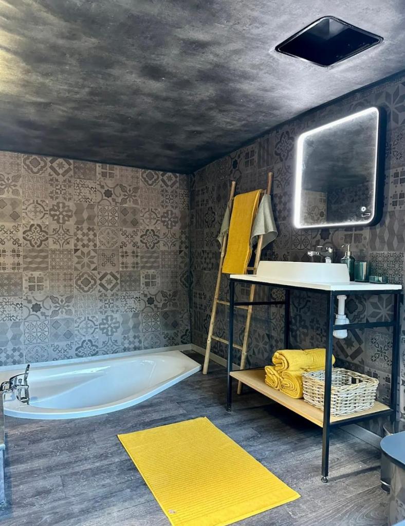 une salle de bain avec une baignoire et un lavabo dans l'établissement Magnifique Pyramide en Verre, à Montarnaud