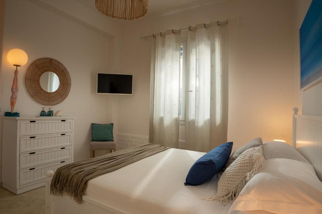 une chambre avec un lit, une commode et un miroir dans l'établissement Natoli Beach House & Villas - Villa Giorgia, à Pollina 50 autres photos