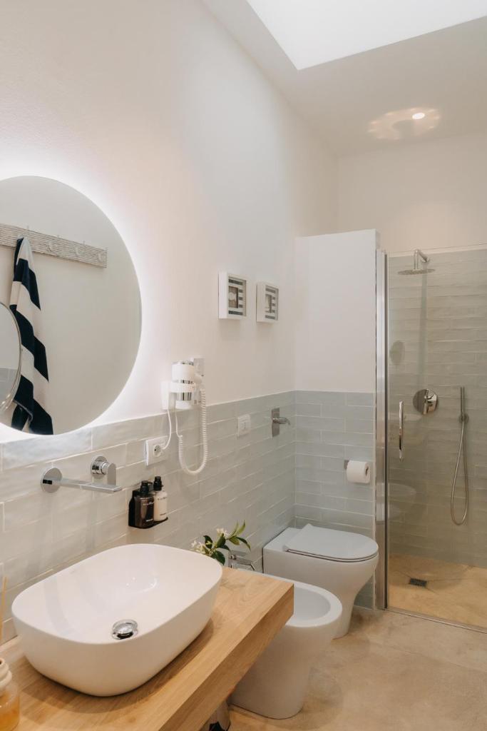 une salle de bain avec un lavabo, des toilettes et une douche dans l'établissement Natoli Beach House & Villas - Villa Giorgia, à Pollina