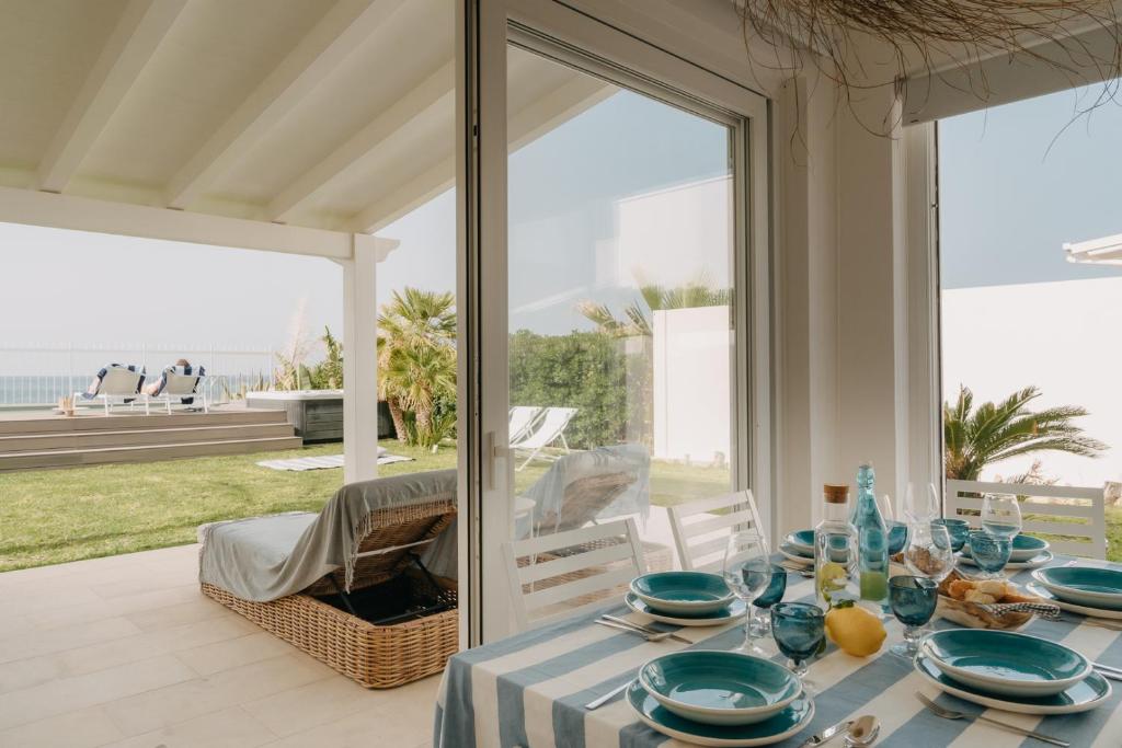 une salle à manger avec une table avec vue sur l'océan dans l'établissement Natoli Beach House & Villas - Villa Giorgia, à Pollina