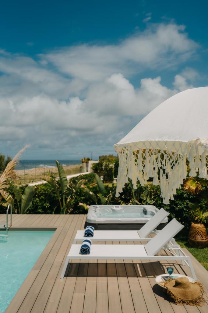 - une piscine avec un bain à remous et un parasol dans l'établissement Natoli Beach House & Villas - Villa Giorgia, à Pollina