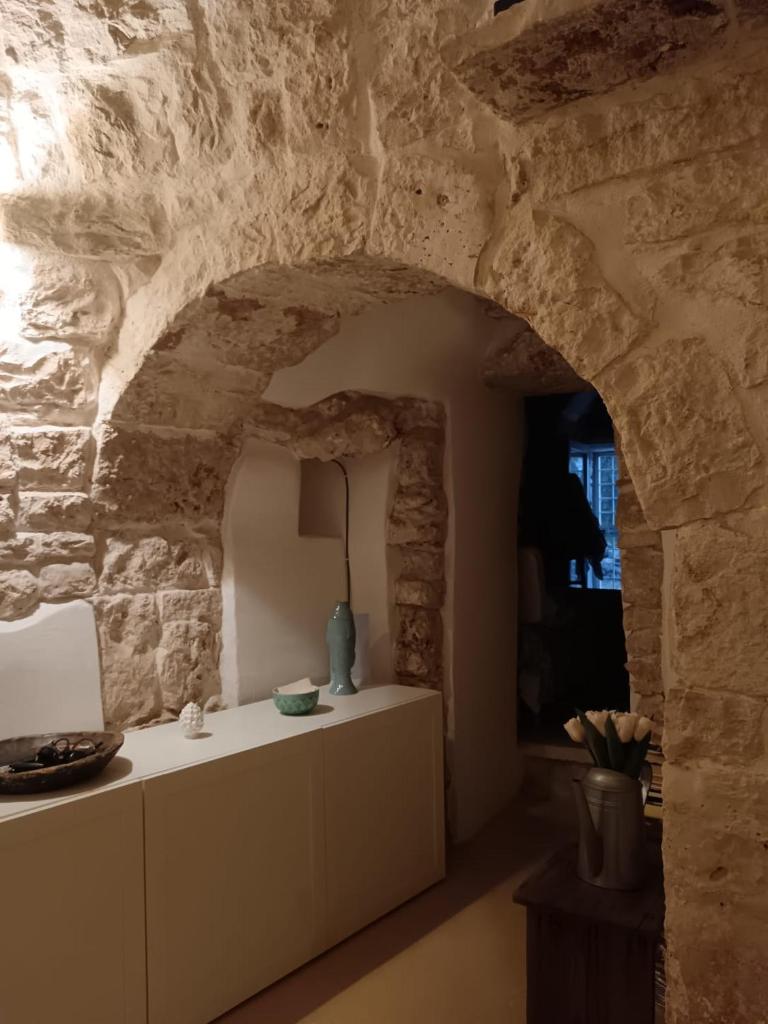 - un salon avec un mur en pierre et une table dans l'établissement Trullo Terracielo, à Ceglie Messapica