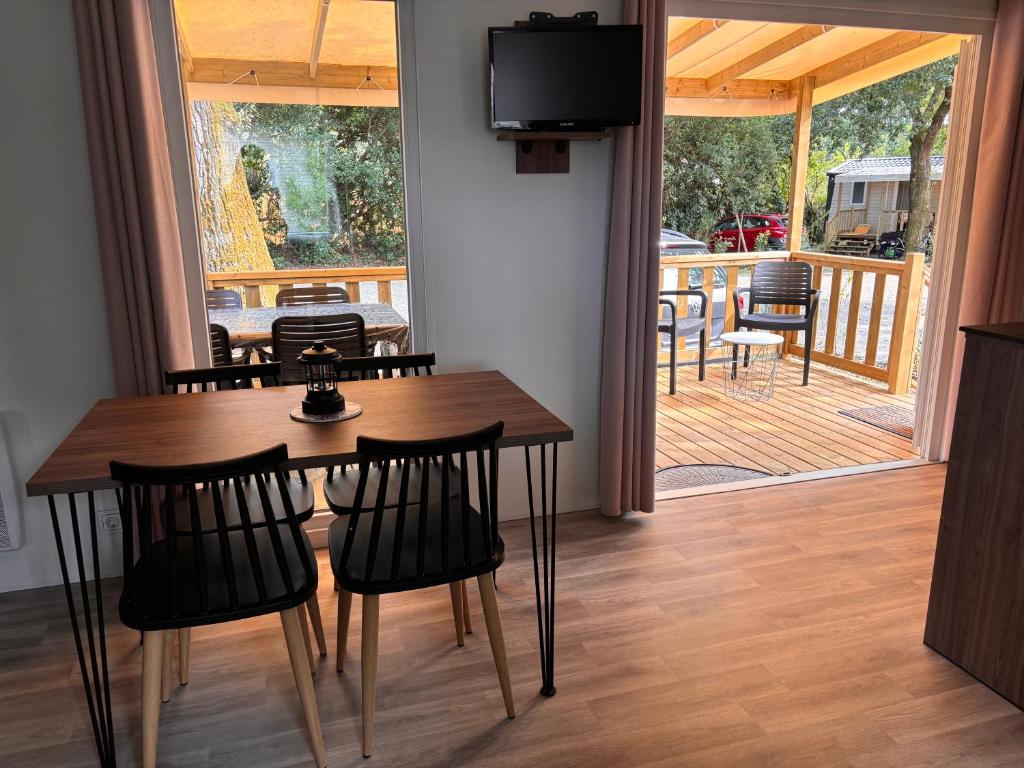 une salle à manger avec une table et des chaises ainsi qu'une terrasse couverte dans l'établissement Mobil home sur le bassin d'Arcachon, à Lège-Cap-Ferret 15 autres photos
