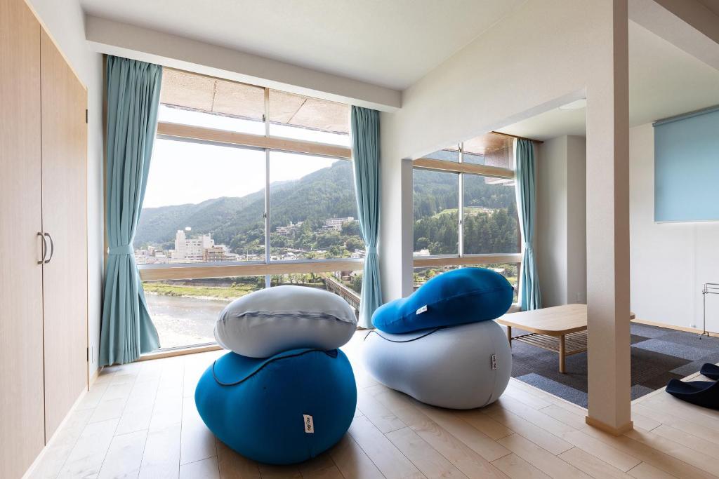 une chambre avec deux poufs devant une fenêtre dans l'établissement Bosenkan, à Gero