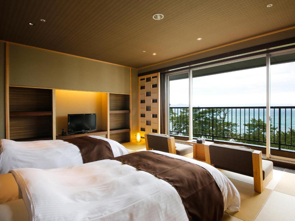 une chambre d'hôtel avec deux lits et une grande fenêtre dans l'établissement Yumekaiyu Awajishima, à Sumoto 37 autres photos