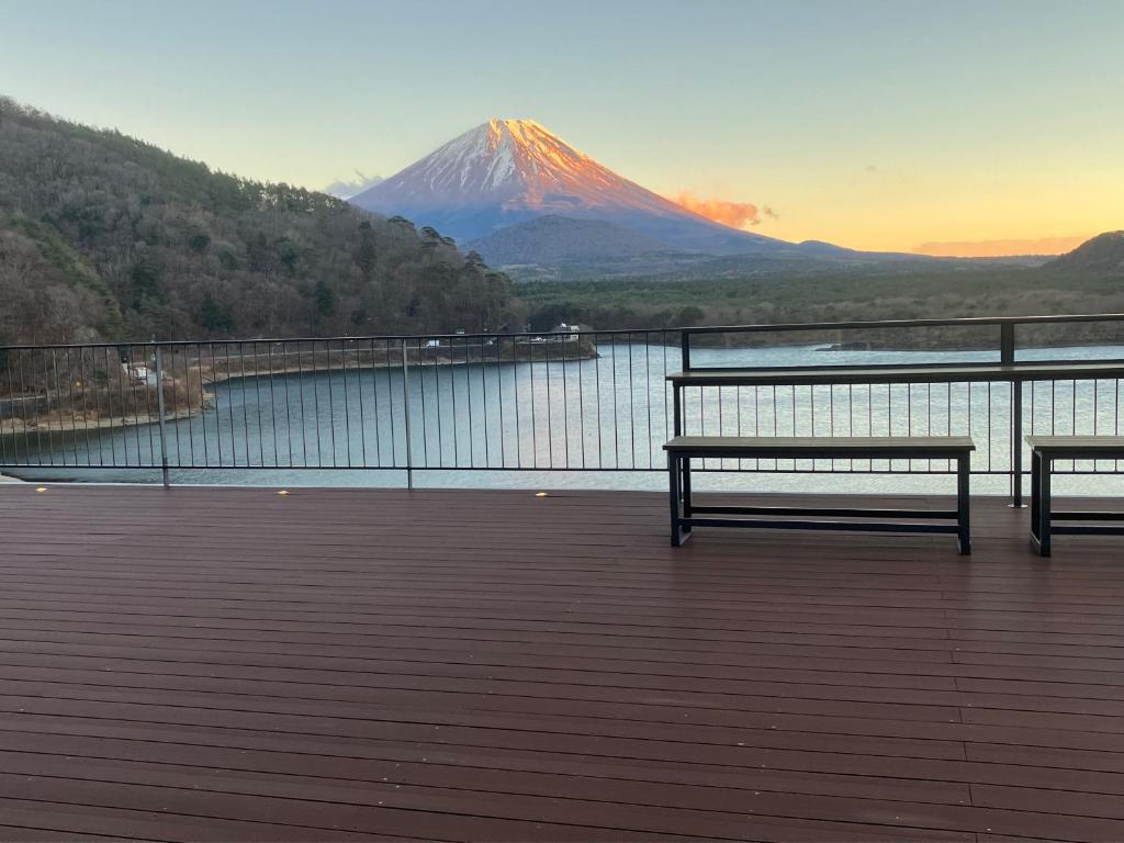 deux bancs assis sur une terrasse donnant sur une montagne dans l'établissement Shoji Lake Hotel, à Fujikawaguchiko