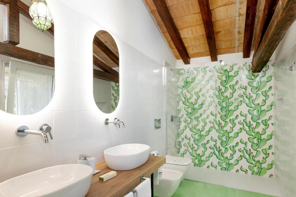 une salle de bain avec un lavabo, des toilettes et une douche dans l'établissement Villa Alcantara di Charme, à Graniti 20 autres photos