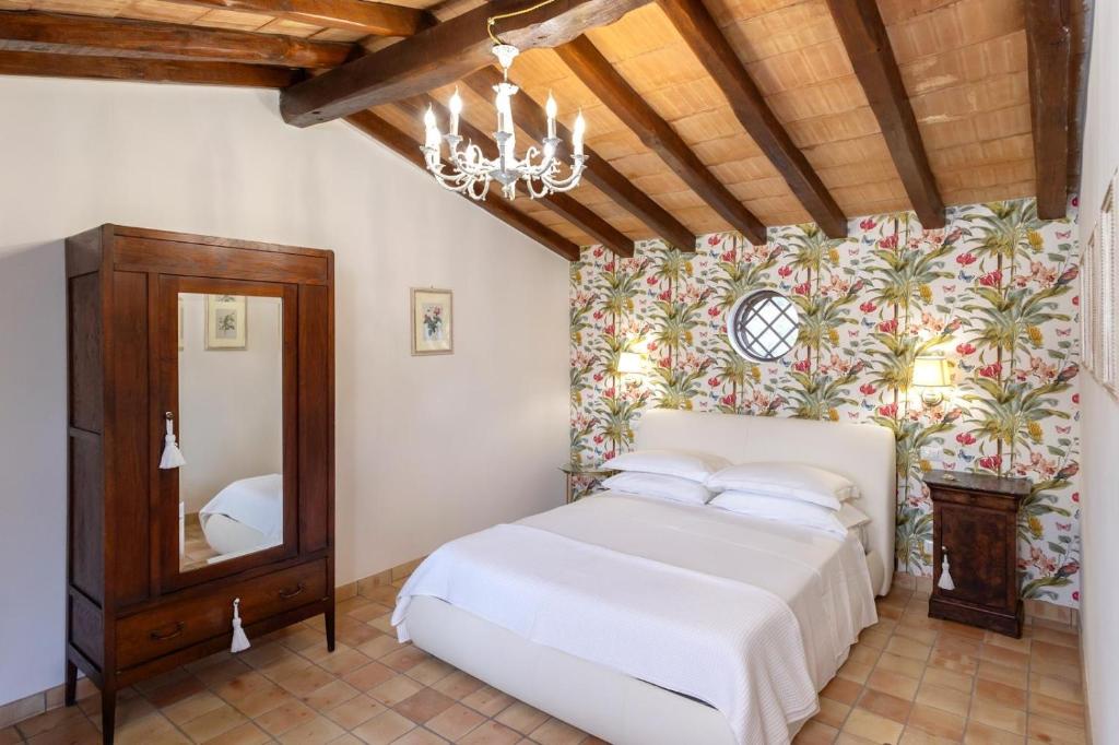- une chambre avec un lit blanc et un lustre dans l'établissement Villa Alcantara di Charme, à Graniti