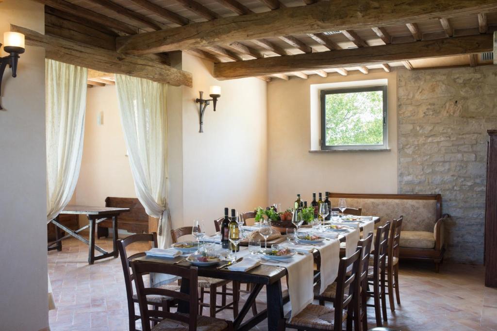 une salle à manger avec une longue table avec des bouteilles de vin dans l'établissement Valle di Assisi Villa Privata, à Tordandrea 8 autres photos
