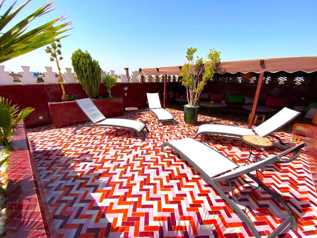 - un ensemble de chaises longues sur la terrasse dans l'établissement Riad La Perle Rouge, à Marrakech