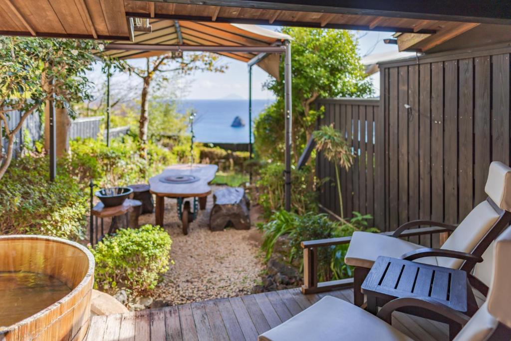 un patio avec une table et des chaises sur une terrasse dans l'établissement Shimoda View Hotel, à Shimoda