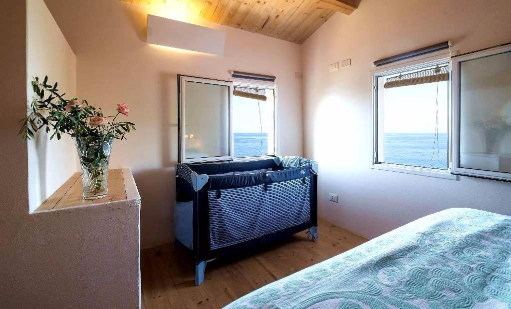 une chambre avec un lit et un vase de fleurs sur une table dans l'établissement Andrea's Home, à Cefalù 57 autres photos