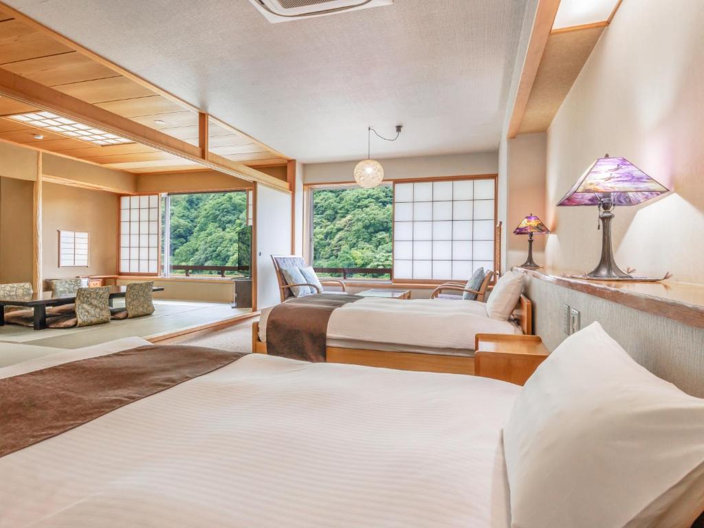 une chambre avec deux lits et un salon dans l'établissement KAMENOI HOTEL Akita Yuze, à Kazuno