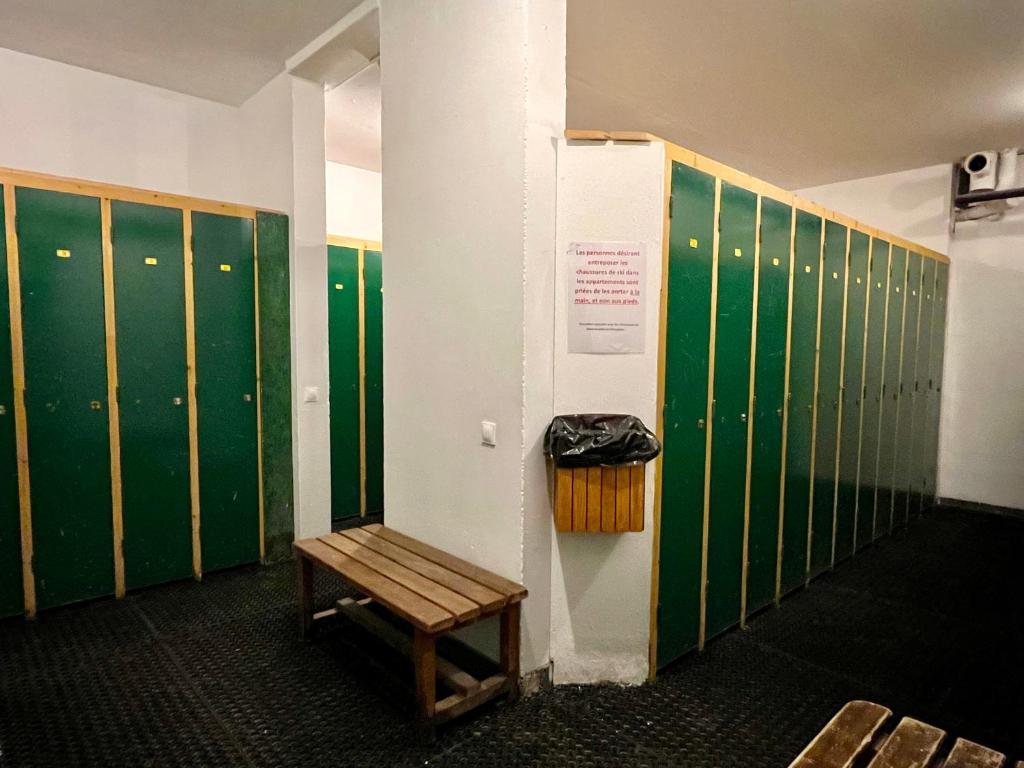 - un casier avec des casiers verts et un banc en bois dans l'établissement RisoulSki Constellation, à Risoul