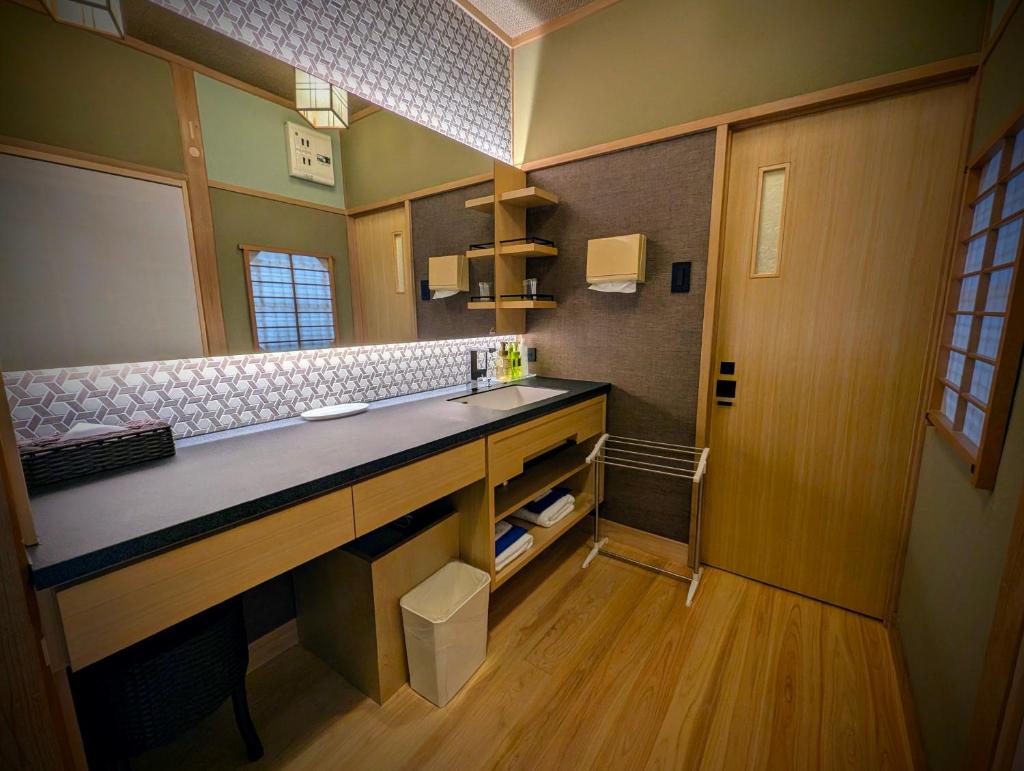 une salle de bain avec un lavabo et un miroir dans l'établissement Ryoso Yufuin Yamadaya, à Yufu