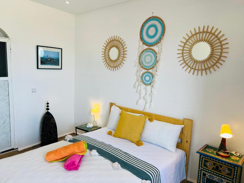 - une chambre avec 2 lits et des miroirs sur le mur dans l'établissement Art Riad Au Bord De La Mer, à El Jadida