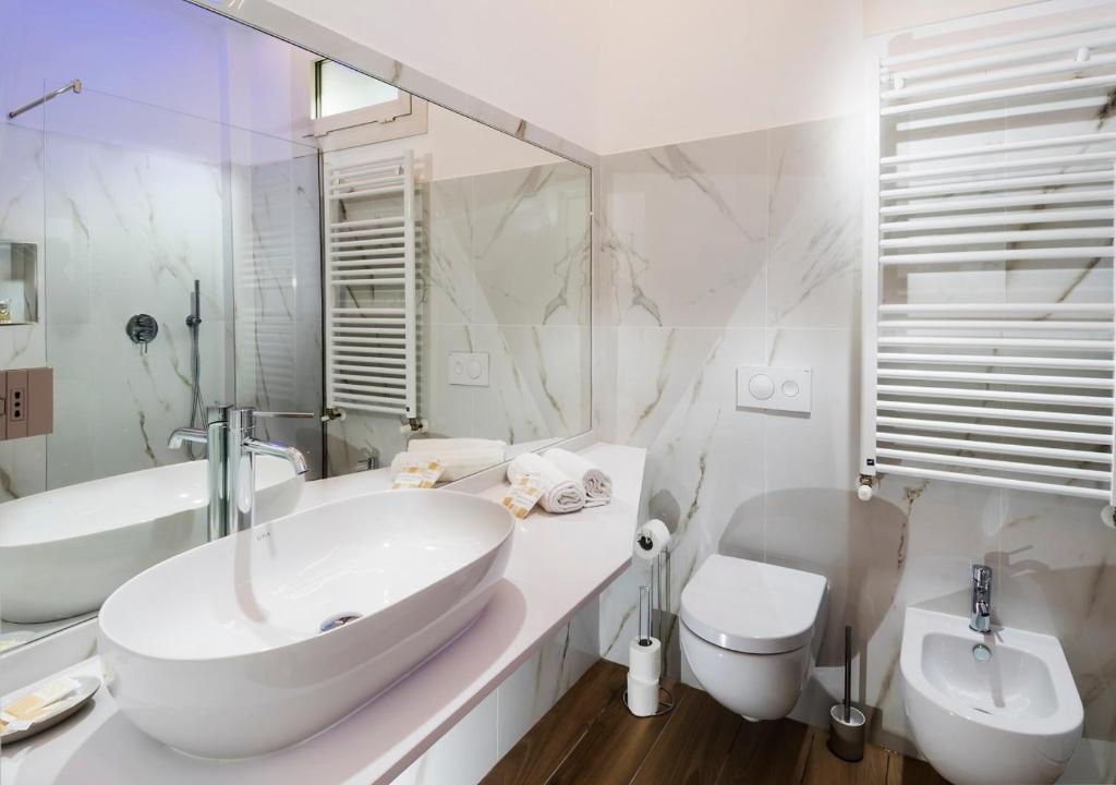 une salle de bain blanche avec un lavabo et des toilettes dans l'établissement Hotel Mediterraneo, à Pesaro