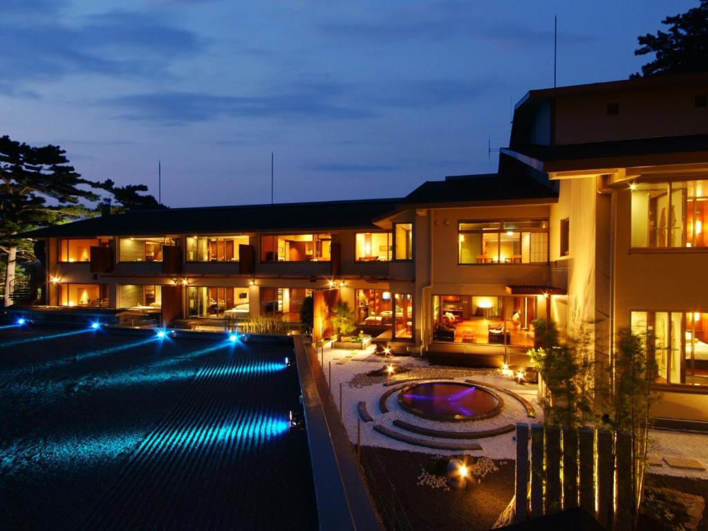 un immeuble avec une piscine la nuit dans l'établissement Hotel Kinparo, à Toyooka