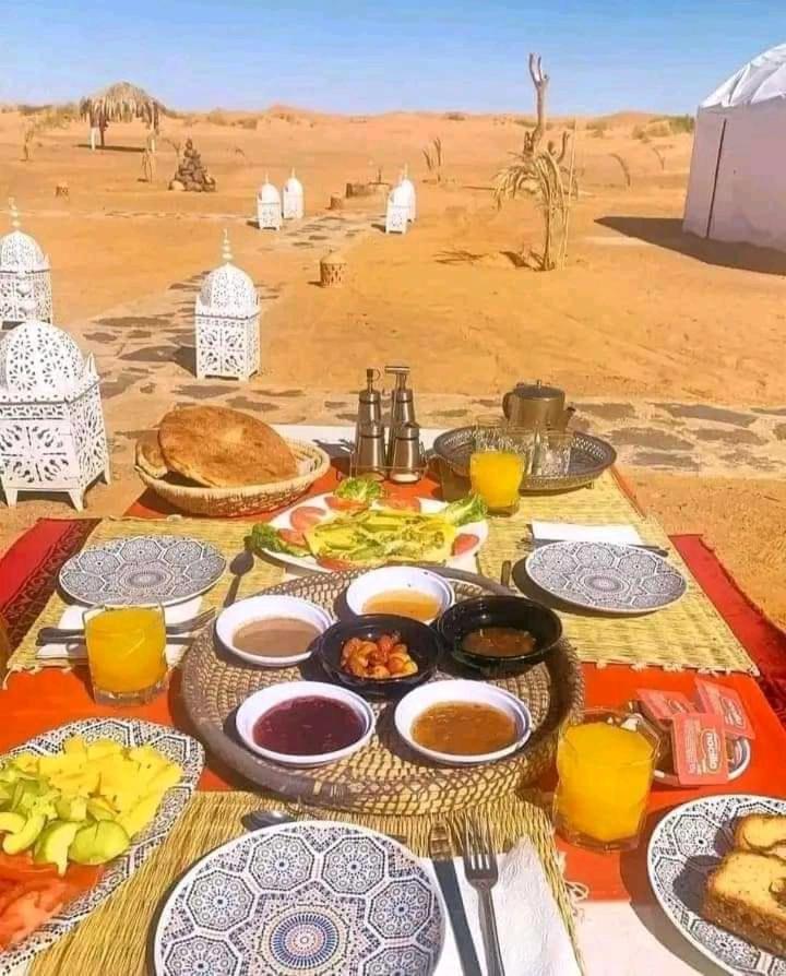 Une table avec de la nourriture dans le désert dans l'établissement GITE Take your time, à Merzouga