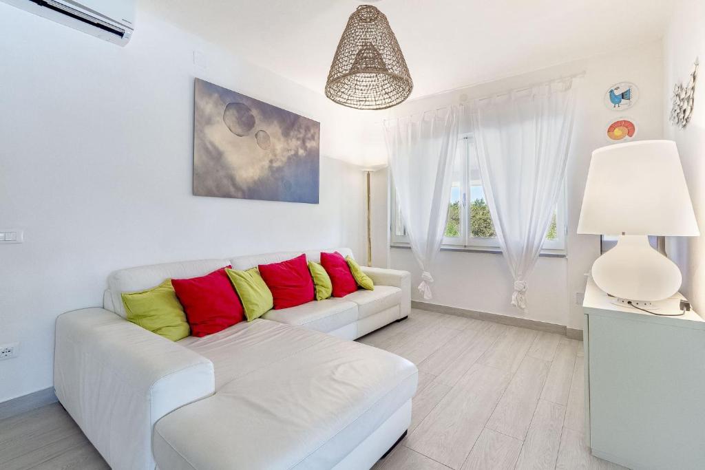 - un salon avec un canapé blanc et des oreillers rouges et jaunes dans l'établissement CASAVIVA - Villa con piscina privata a Stintino, à Stintino 35 autres photos
