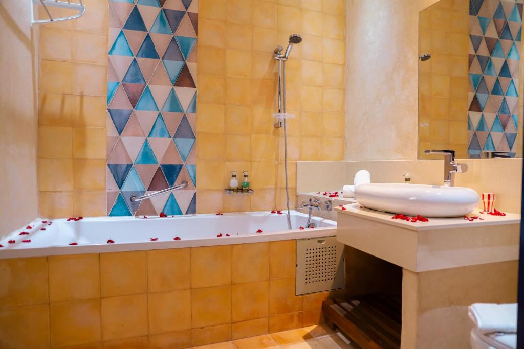 une salle de bain avec une baignoire et un lavabo dans l'établissement Riad YAHIA ZAMANE, à Essaouira