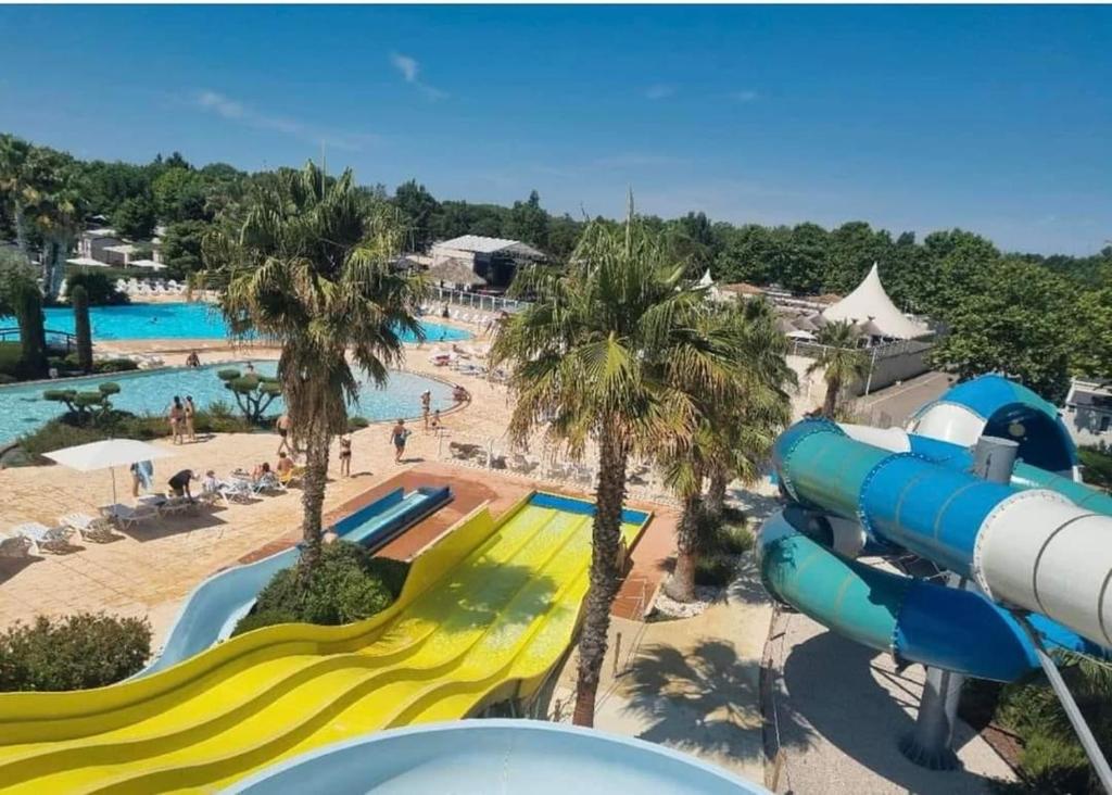 - une vue sur un parc aquatique avec un toboggan dans l'établissement Mobilhome 6P Camping la Carabasse Vias, à Vias